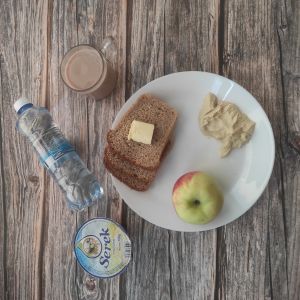 Zdjęcie przedstawia dietę podstawową: Dieta podstawowa  Kakao Zacierka na mleku Chleb mieszany pszenno-żytni Masło extra Dżem Jabłko Serek homo naturalny Woda źródlana